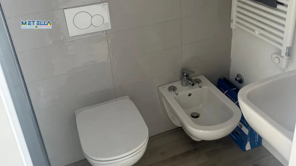 Interno di modulo bagno con wc e rivestimenti lavabili