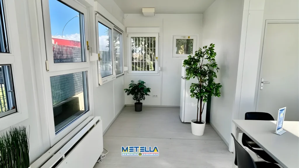 Interno di ufficio modulare con postazioni di lavoro e illuminazione naturale