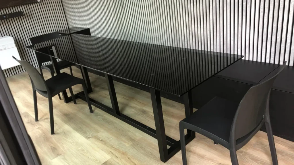 Interno sala riunioni allestito con ampio tavolo, sedute e rifiniture in legno